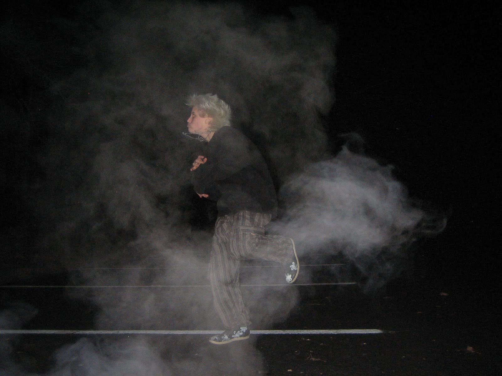 Man dancing around in a cloud of smoke. 