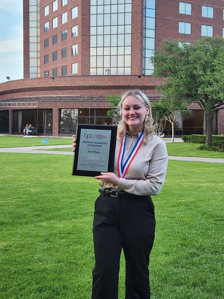 Girl holding an award plaque.