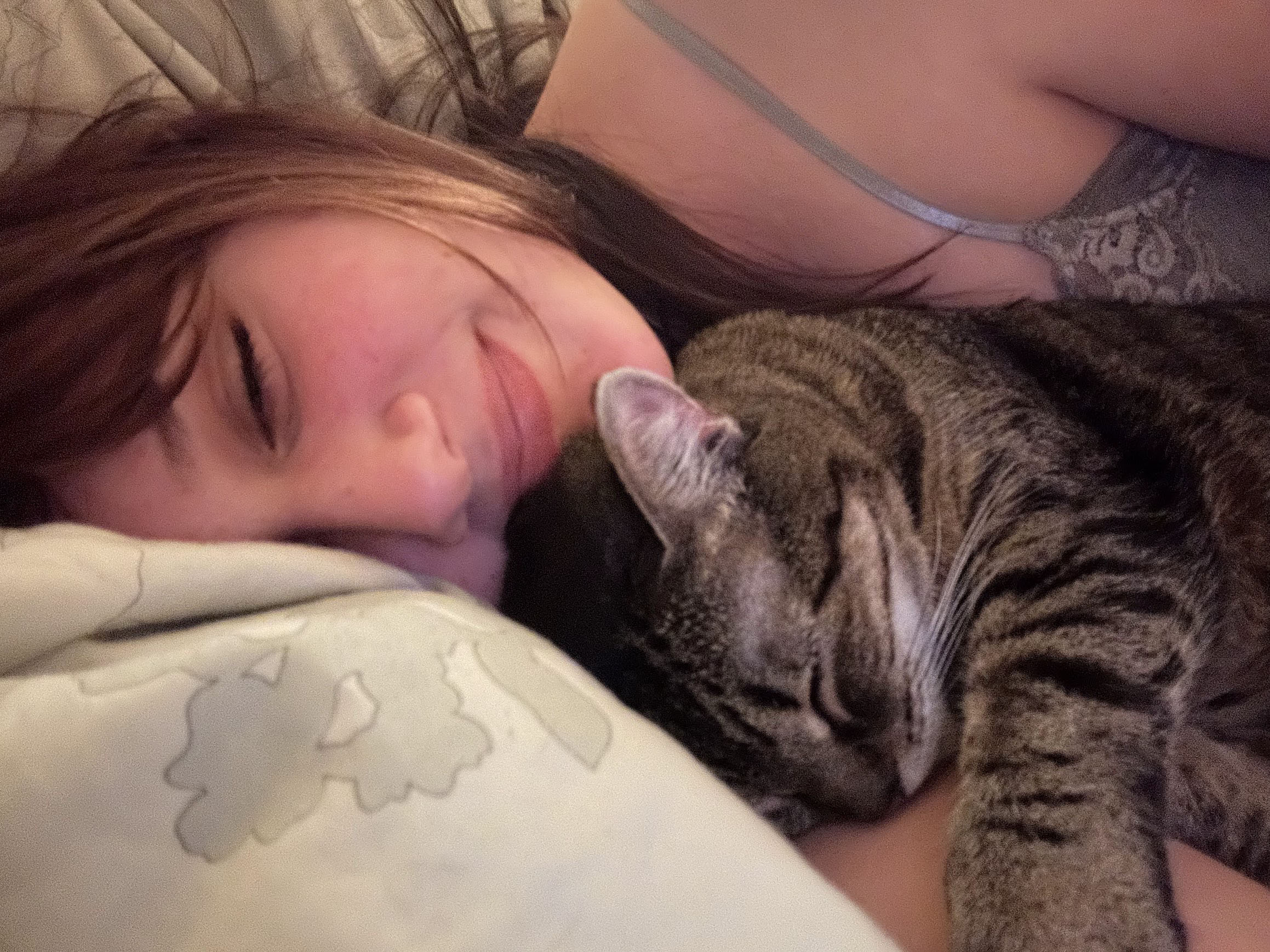 Girl cuddling with a small cat.